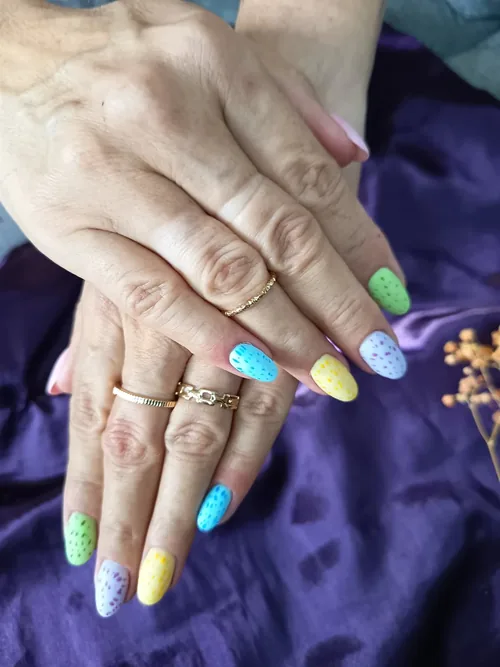 Nail art pastel à pois blancs, une teinte différente par ongle, forme amande